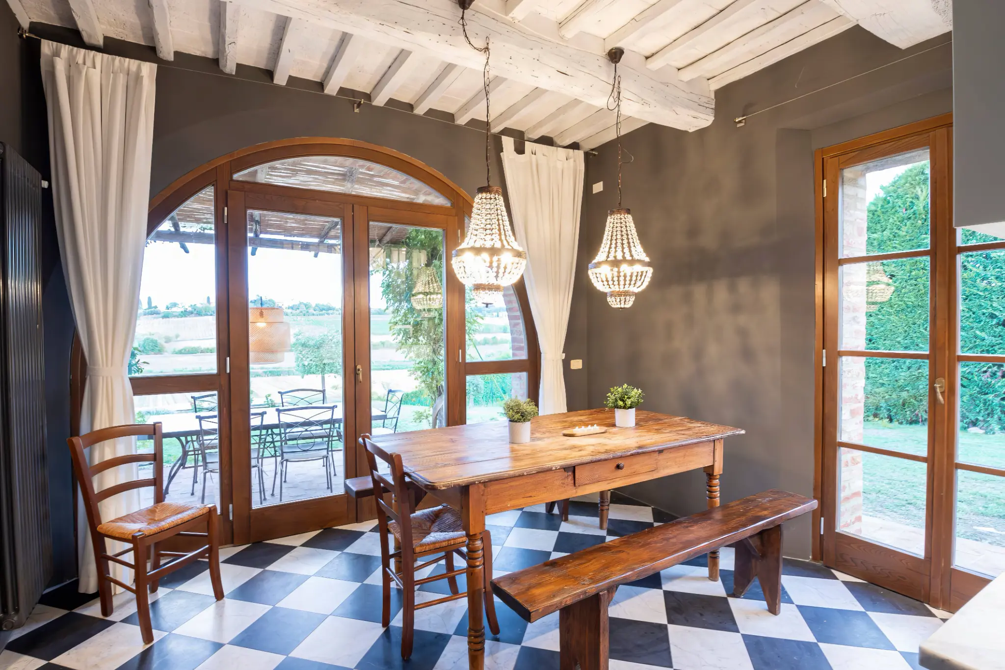 Sala da pranzo con lampadari e vista giardino