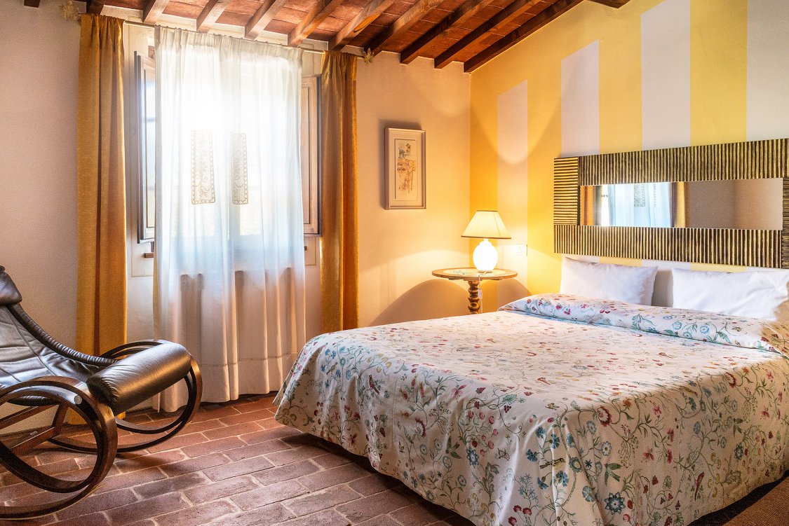 Camera con pareti gialle a righe e sedia a dondolo