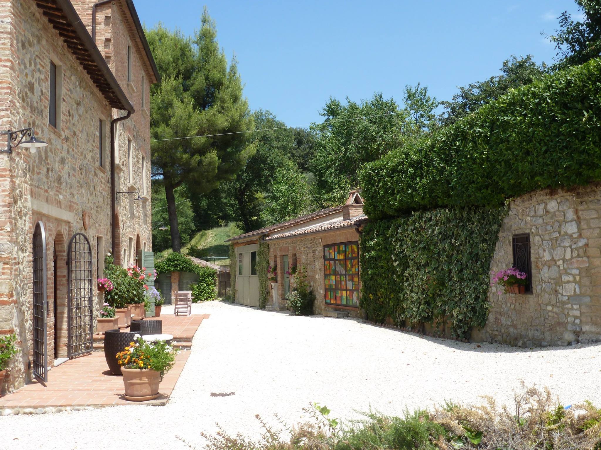 Cortile con annessi in pietra, edera e vetrata artistica